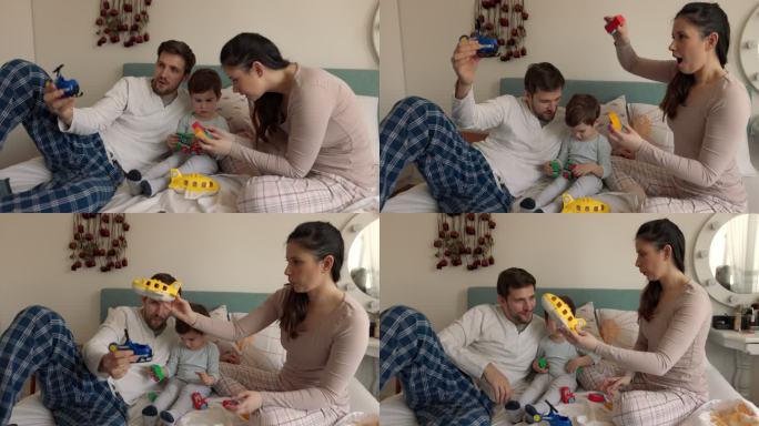 微笑的男人和女人在卧室里和他们的儿子玩耍