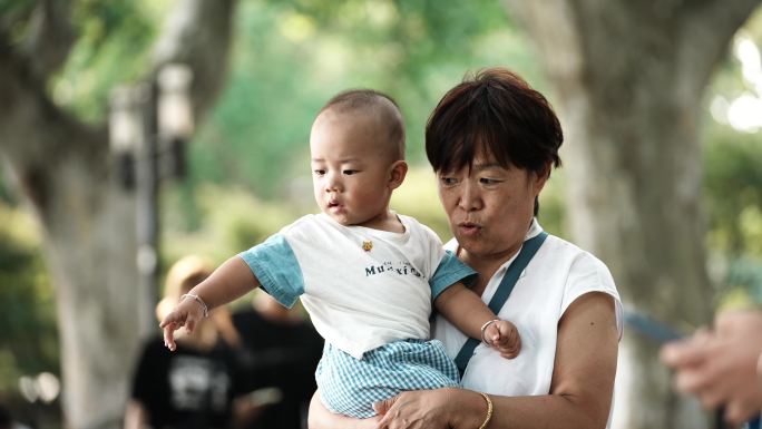 杭州西湖抱孩子的老人