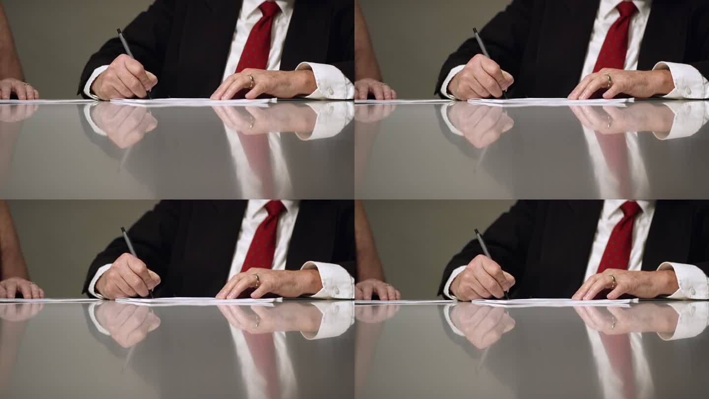 一位已婚白人商人在室内会议桌上签署文件的慢镜头