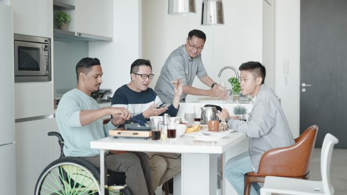 周末，坐轮椅的亚裔印度残疾人在公寓厨房为朋友们做早餐
