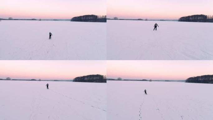 4K无人机视角青少年男孩在广阔、宁静的冰冻湖面上滑冰，实时