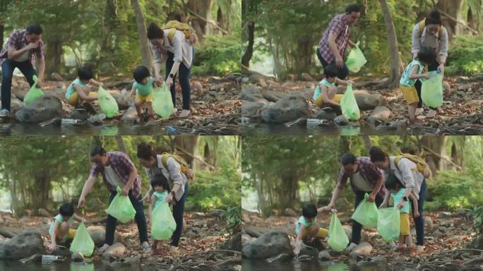 亚裔家庭志愿者在河边捡起一个塑料瓶