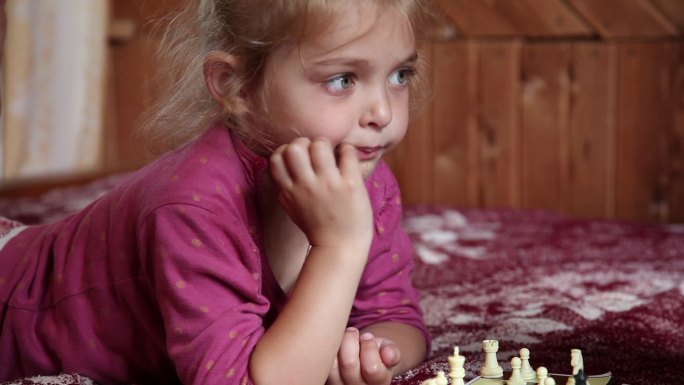 小女孩在床上下棋时消极地摇头