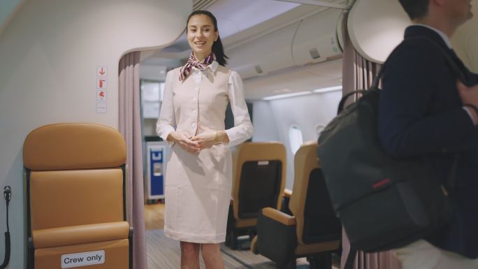 空中小姐站着欢迎旅客登机，欢迎旅客上路。