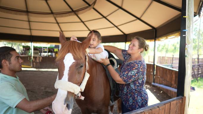 孤独症女孩在私人中心接受马的治疗。