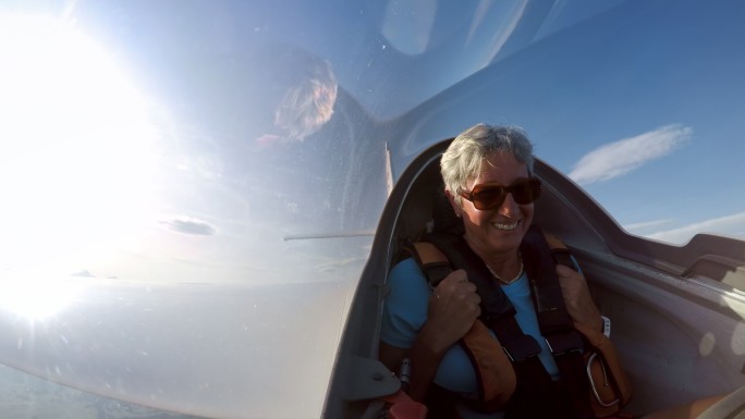 LD女乘客在阳光明媚的天空中滑翔机滑翔时大笑