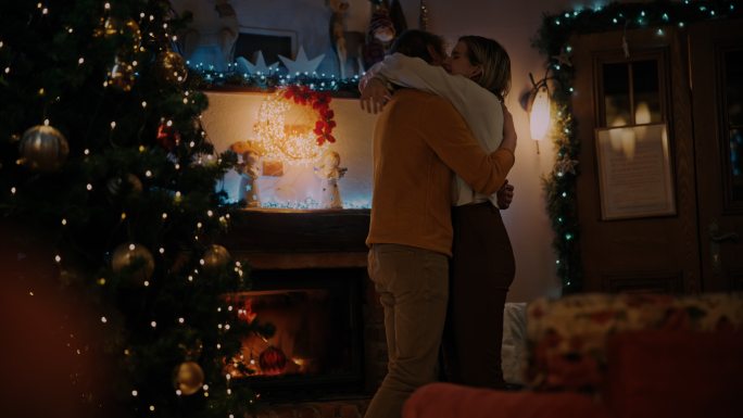 圣诞节期间，SLO MO DS年轻情侣在壁炉前拥抱