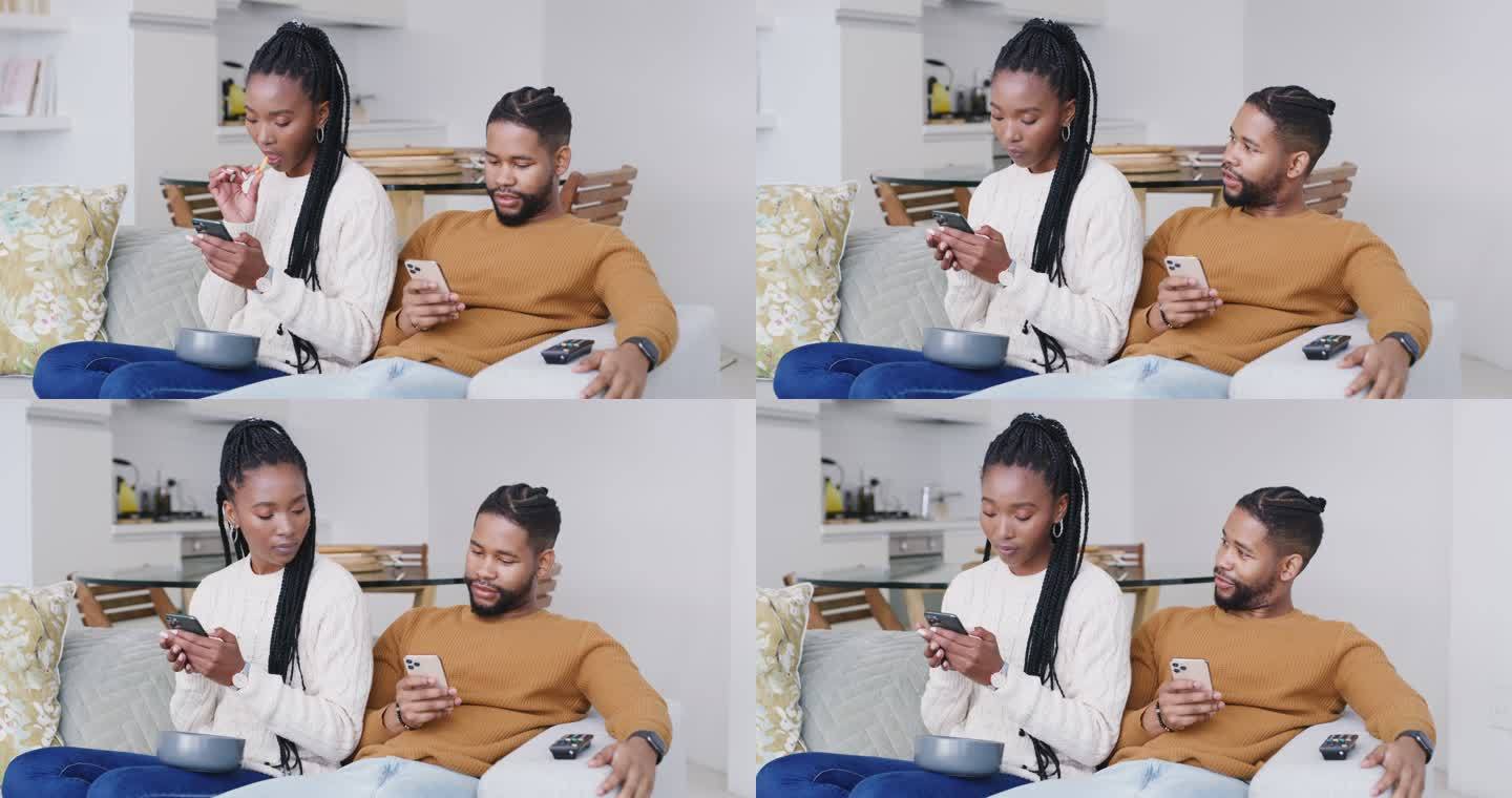 一对年轻夫妇在家里的沙发上使用智能手机。男人和女人看起来无聊和不开心，在用手机上网时相互忽视