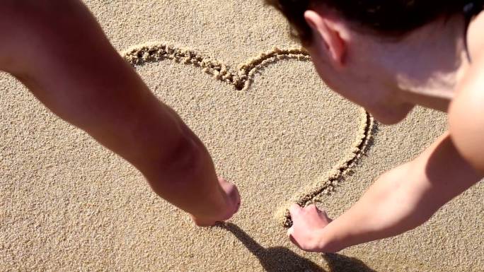 情侣在沙滩上画出一颗心