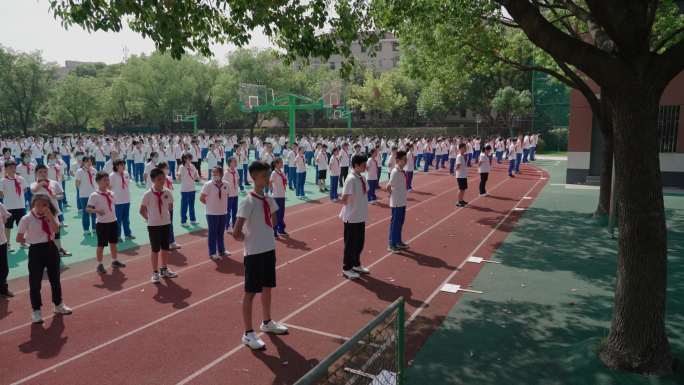 中小学生在课间的操场上做广播体操集合