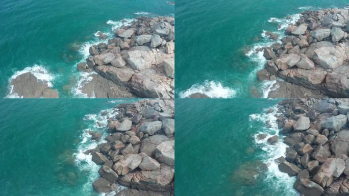 航拍视角浪花拍打在礁石上