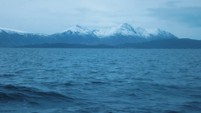 在波涛汹涌的海面上观看，背景是海浪和罗浮顿群岛