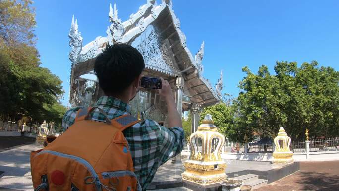 亚洲男子背包旅行者在度假期间在古老的宝塔寺泰国建筑中散步