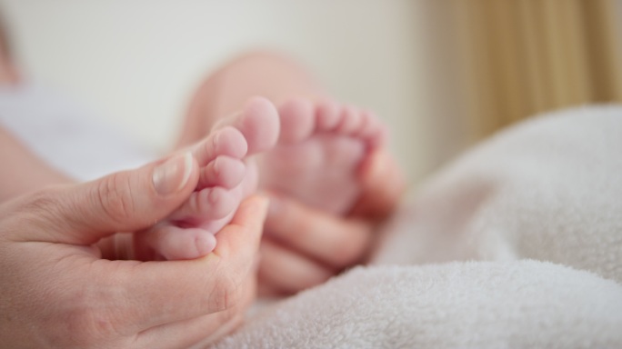 母亲的手抚摸着婴儿的脚