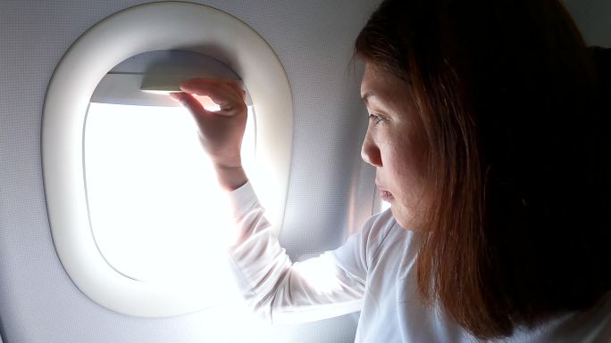 女乘客在飞行过程中打开飞机窗户并向外看