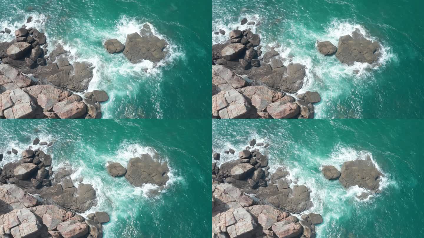 航拍视角浪花拍打在礁石上