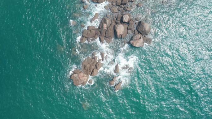 航拍俯视浪花拍打在礁石上