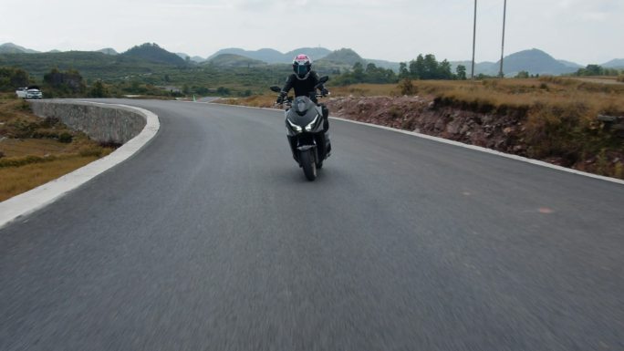 踏板摩托车在山路上骑行、压弯、烧胎