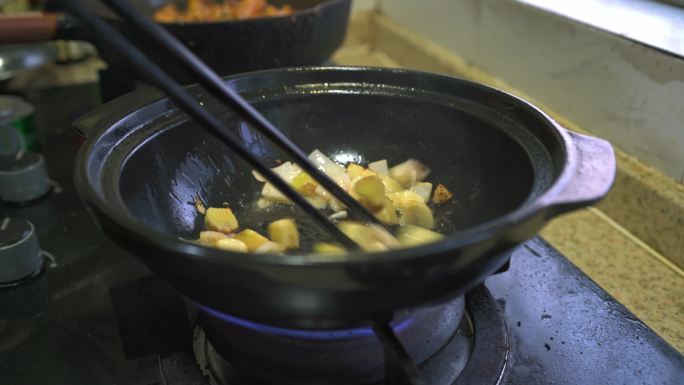 粤菜厨房里一位厨师在制作广式啫啫鸡煲