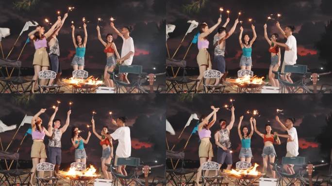 一群亚洲年轻男女晚上在海滩上聚会。迷人的朋友，旅行者，一边在海边露营一边唱歌跳舞，一起在热带海岛享受
