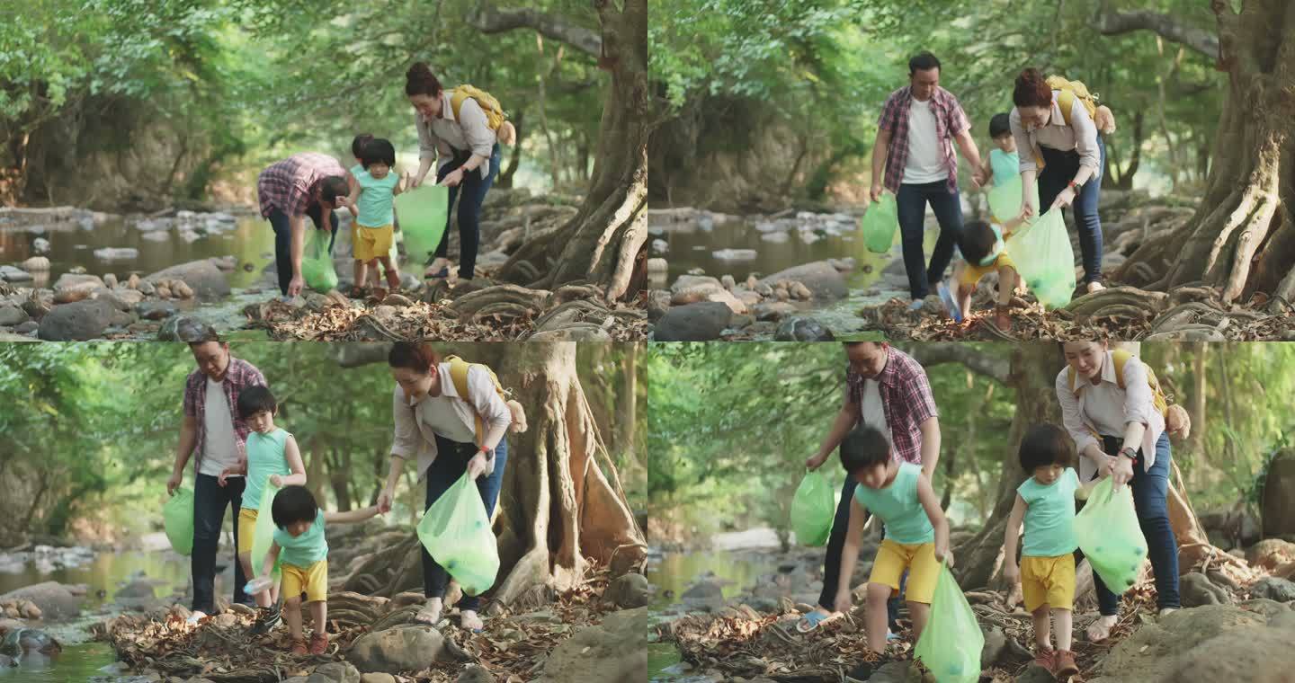 亚裔家庭志愿者在河边捡起一个塑料瓶