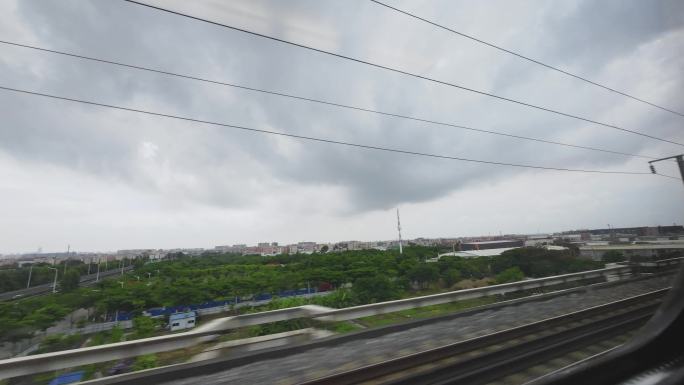 高速行驶的高铁动车车窗外景阴雨天气