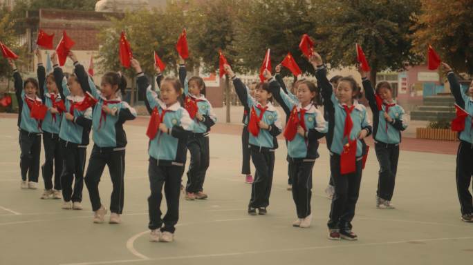 小学生庆祝国庆节，做操、舞动国旗，奔跑