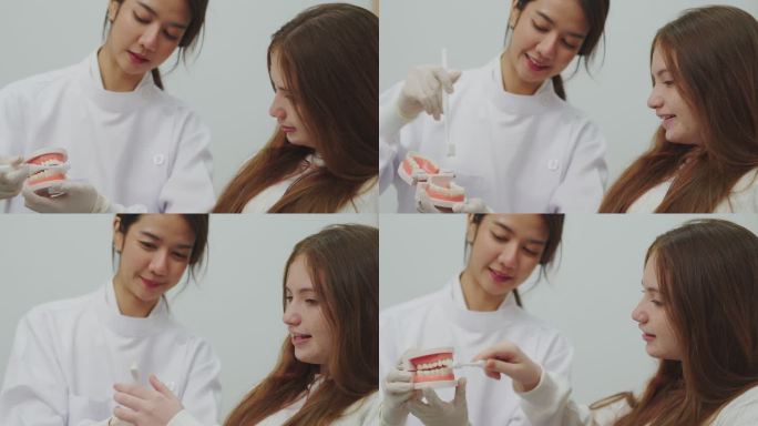 年轻的女牙医和十几岁的女孩在牙科诊所的牙医练习室拿着模型牙和牙线。