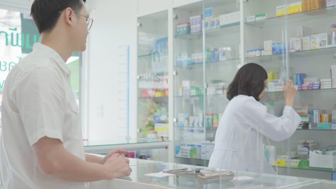 药房药店的药剂师使用药盘清点药丸并按处方配药给患者。药剂师向病人解释如何服药以恢复健康。健康和医疗理