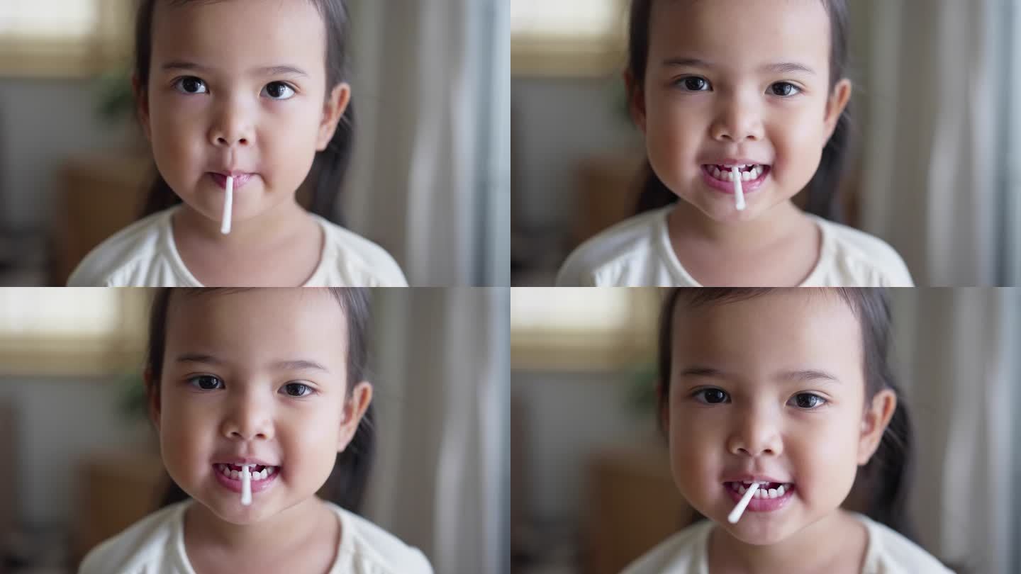 亚洲小女孩吃糖果棒棒糖看着相机的肖像
