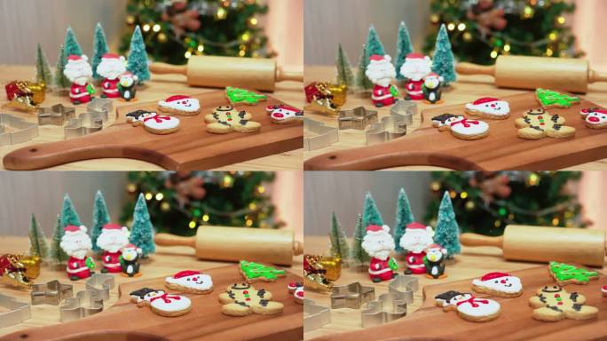 特写娃娃镜头：一系列工具和自制圣诞饼干，上面装饰着奶油、红鞋、雪人、姜饼、鹿头、圣诞树、圣诞老人的脸