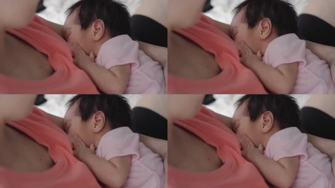 亚洲妇女坐着哺乳她的婴儿