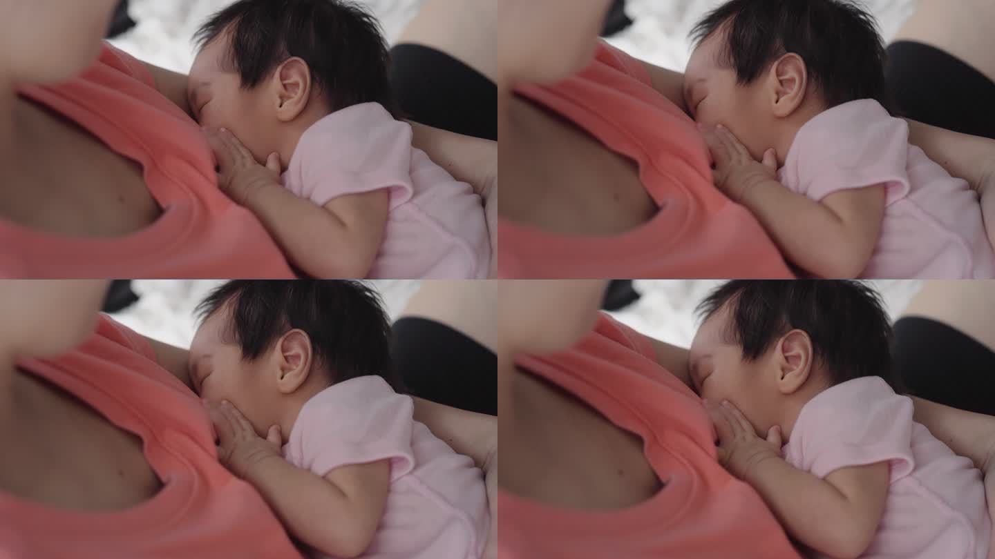 亚洲妇女坐着哺乳她的婴儿