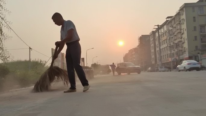 一个扫街的男子 扫街道 清理街道沙尘