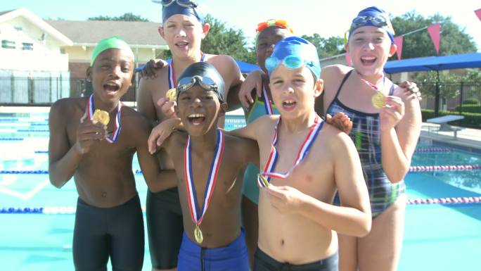 游泳队的孩子们骄傲地举起奖牌