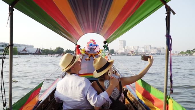 情侣情侣在湄南河的浪漫时刻驾着长尾船自拍照片。旅行生活方式。