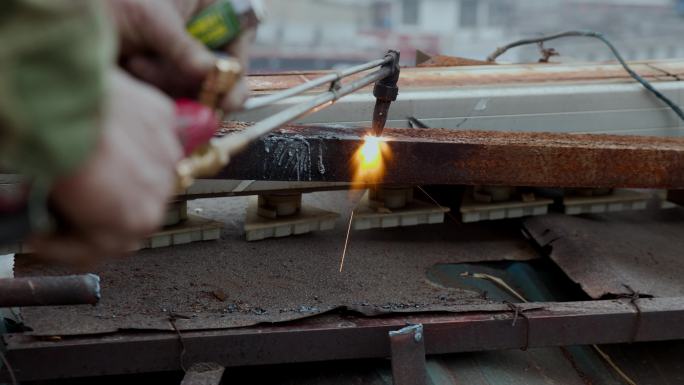 建筑工人用火焰切割废金属