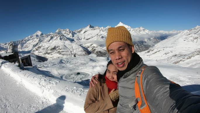 浪漫情侣携手在瑞士冰川3000号拍摄照片