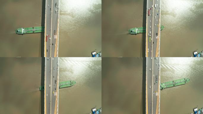 航拍俯视油轮通过桥下公路到达炼油厂进行运输或能源概念背景。