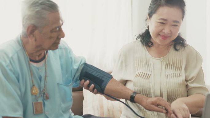 亚洲老年夫妇在家检查血压。