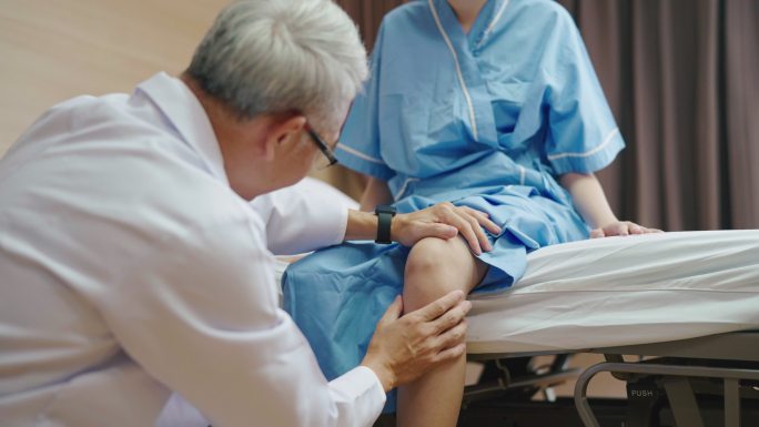 一位亚洲女性正在接受医生的膝盖检查