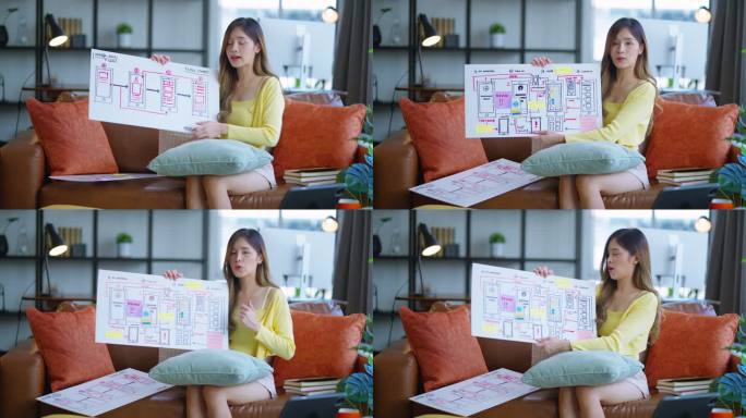 年轻的亚洲自由编程女性视频会议与客户进行视频会议。女程序员在线向同事解释ux新应用屏幕智能手机的工作
