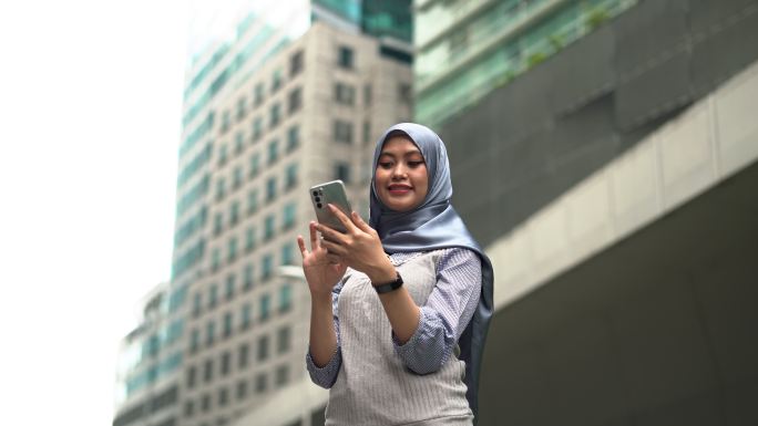 使用智能手机的年轻马来妇女