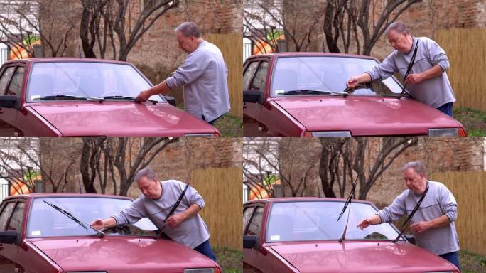 一位老人手里拿着水管，在后院洗车。
