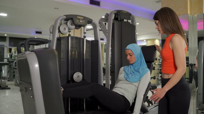 女子健身与健身私人教练在健身房锻炼