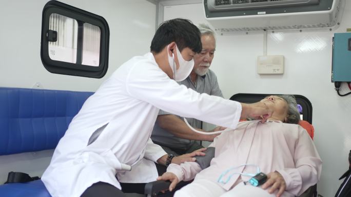 医生在救护车里检查病人。和病人的丈夫一起。