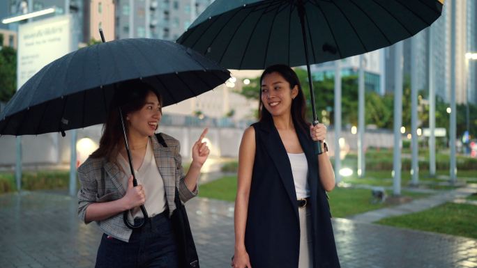 大雨中，两名亚洲妇女正在回家的路上。