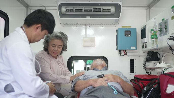 医生在救护车里检查病人。和病人的妻子一起。