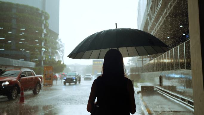 在大雨中撑着雨伞的孤独、悲伤的女商人