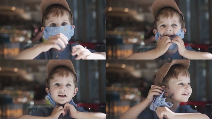 小男孩在咖啡馆脱下可重复使用的防护织物口罩
